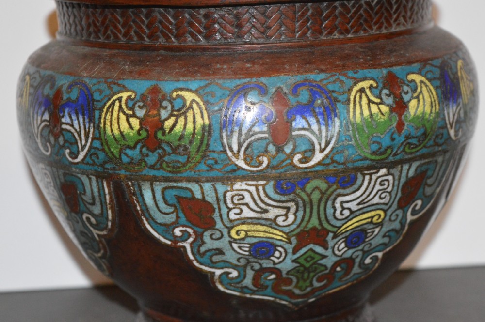 A late 19th-century Chinese bronze vessel decorated with cloisonne enamel bat motifs and geometric patterns in turquoise, blue, red, and yellow.