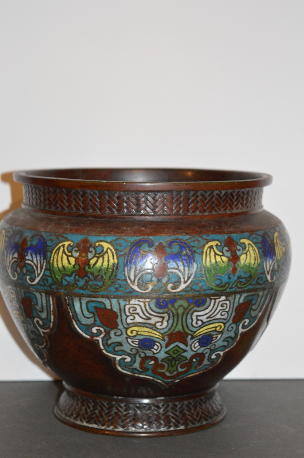 A late 19th-century Chinese bronze vessel decorated with cloisonne enamel bat motifs and geometric patterns in turquoise, blue, red, and yellow. View VIII