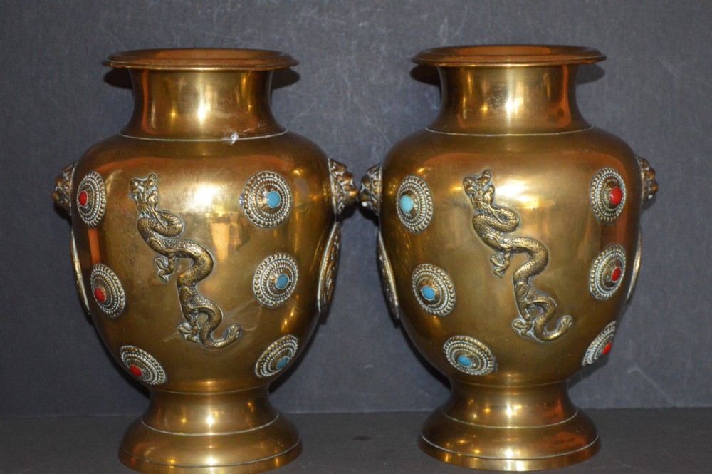A matching pair of polished brass baluster vases featuring applied serpentine dragon motifs and circular beaded medallions set with turquoise and coral cabochons.