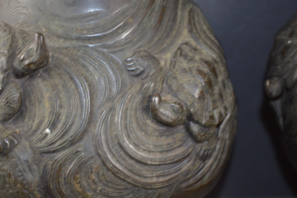 A pair of dark patinated Japanese bronze vases featuring high-relief carvings of flying birds and long-tailed turtles amongst stylised water waves. View VI