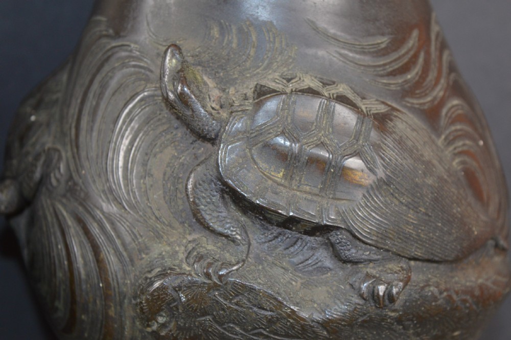 A pair of dark patinated Japanese bronze vases featuring high-relief carvings of flying birds and long-tailed turtles amongst stylised water waves. View VII