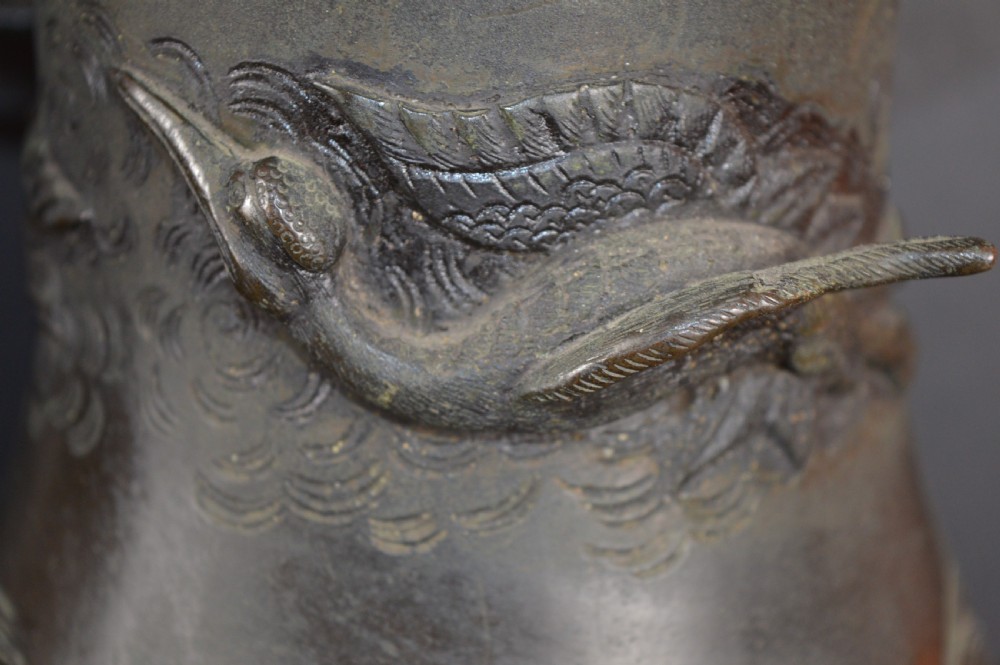 A pair of dark patinated Japanese bronze vases featuring high-relief carvings of flying birds and long-tailed turtles amongst stylised water waves. View VIII