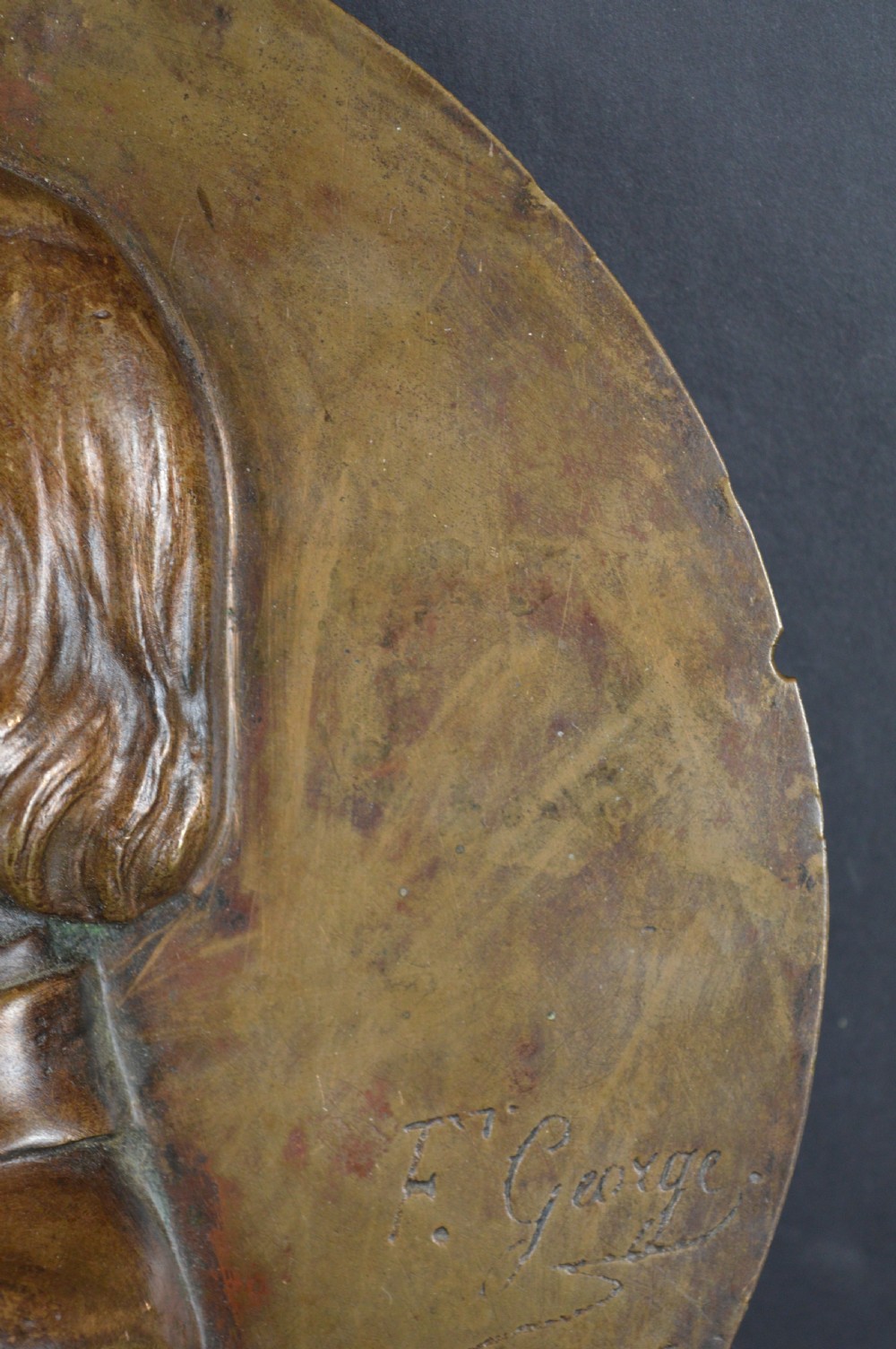 A circular patinated bronze relief plaque displaying a left-facing profile portrait of a man with a moustache, high collar, and bowtie, inscribed F George 1856. View VI