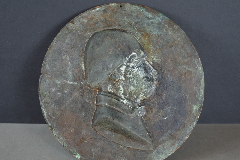 A circular patinated bronze relief plaque displaying a left-facing profile portrait of a man with a moustache, high collar, and bowtie, inscribed F George 1856. View VII