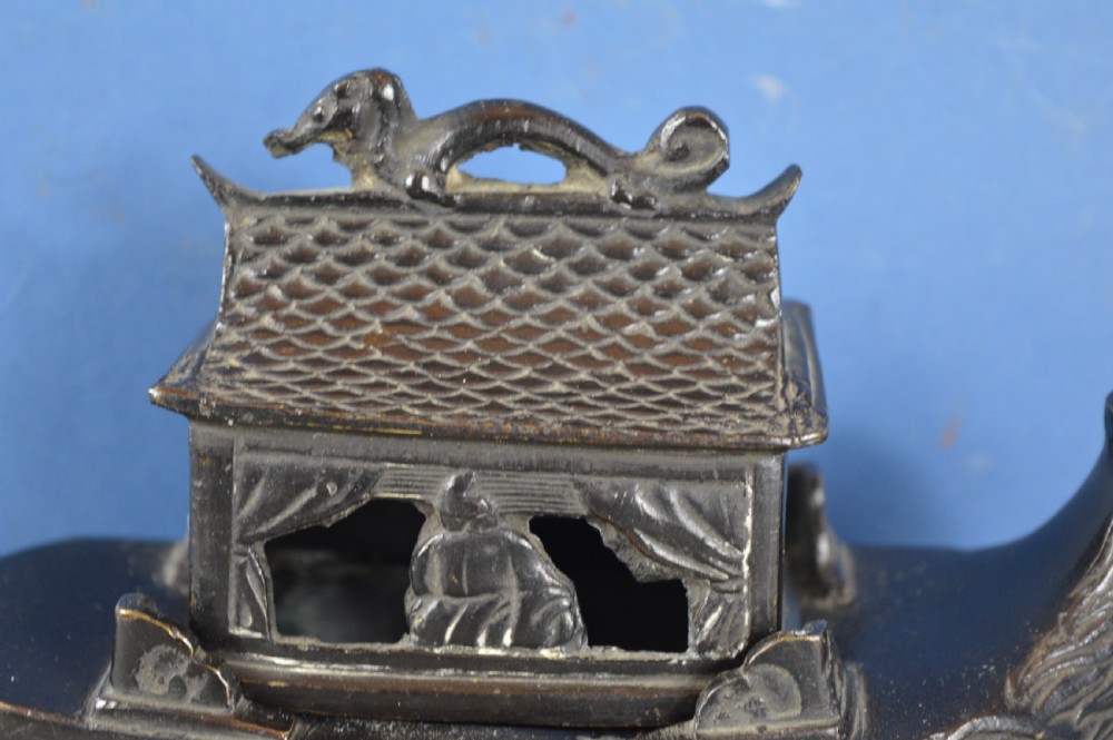 A dark patinated bronze Chinese censer cast in the form of a junk boat featuring a pagoda cabin, figure, and bird prow. View II