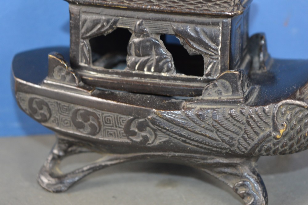 A dark patinated bronze Chinese censer cast in the form of a junk boat featuring a pagoda cabin, figure, and bird prow. View IV