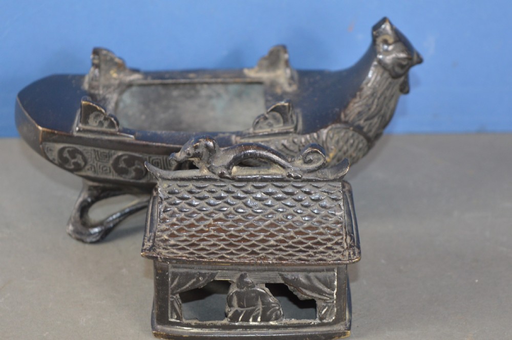 A dark patinated bronze Chinese censer cast in the form of a junk boat featuring a pagoda cabin, figure, and bird prow. View VI