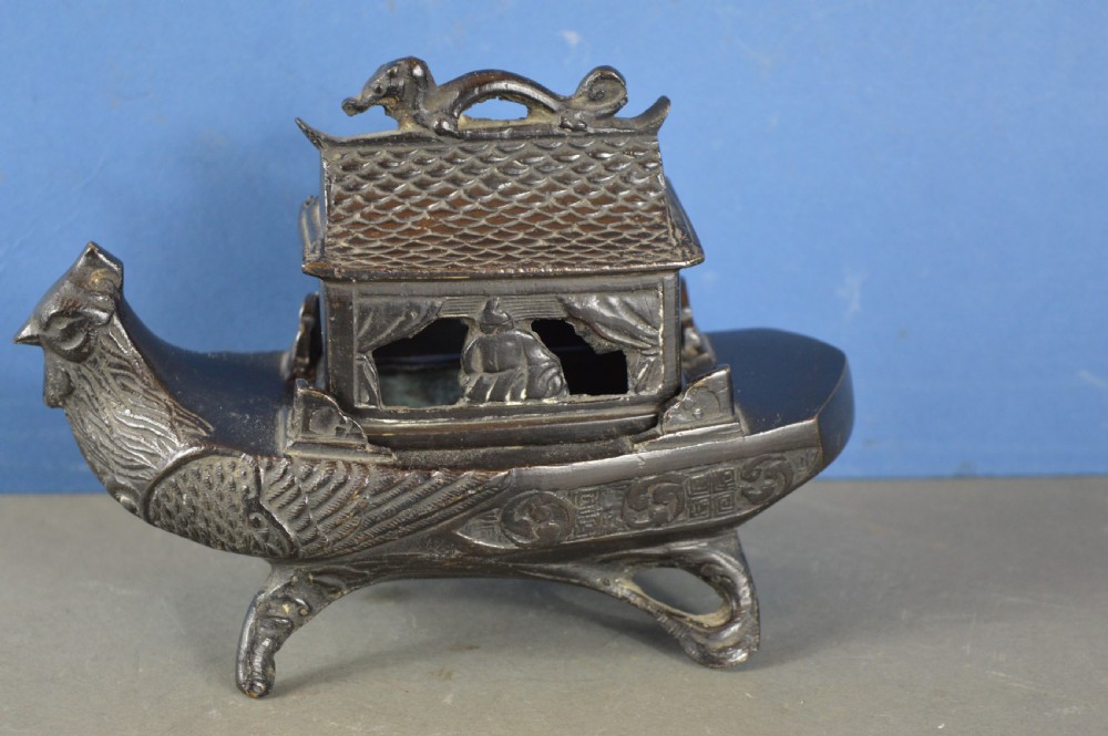 A dark patinated bronze Chinese censer cast in the form of a junk boat featuring a pagoda cabin, figure, and bird prow. View VIII