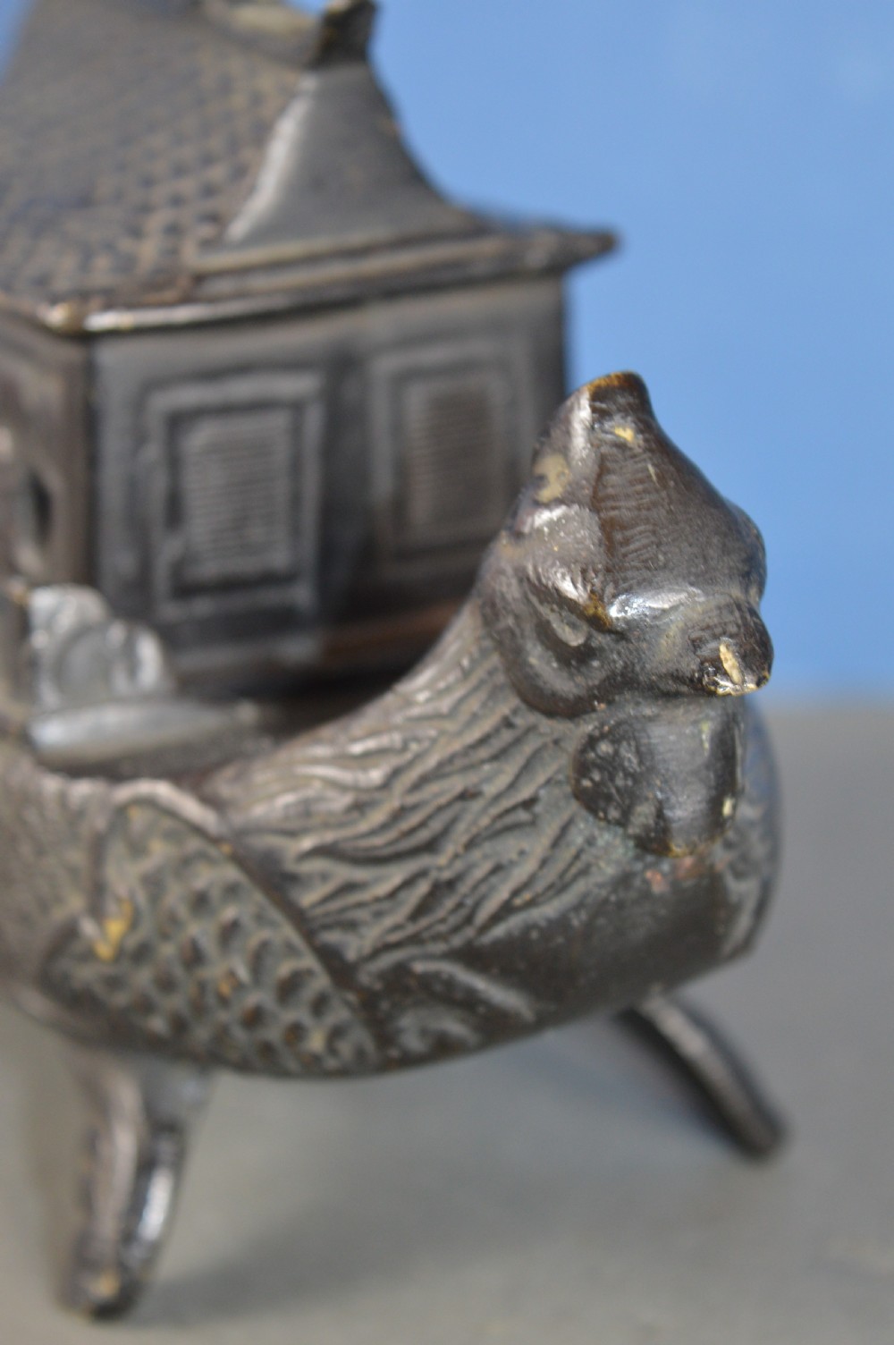 A dark patinated bronze Chinese censer cast in the form of a junk boat featuring a pagoda cabin, figure, and bird prow. View X
