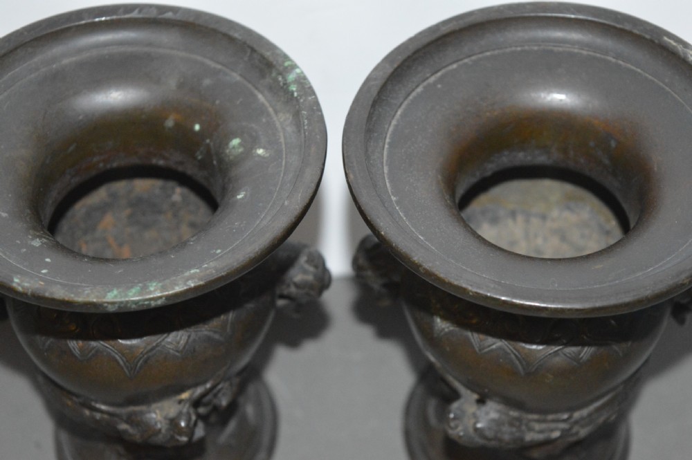 A pair of dark brown cast bronze Chinese vases featuring high-relief dragon motifs, beast head handles, and wide dished rims. View IV