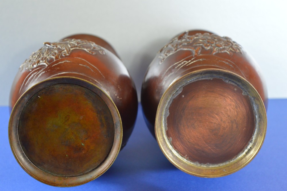 A pair of patinated dark brown Chinese bronze baluster vases with dragon handles and relief floral carvings. View VIII
