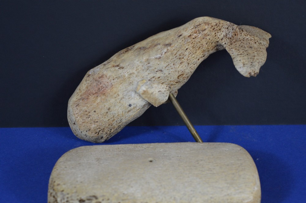 A hand-carved whale figure made from porous whalebone mounted on a metal pin above a rectangular bone plinth base. View X
