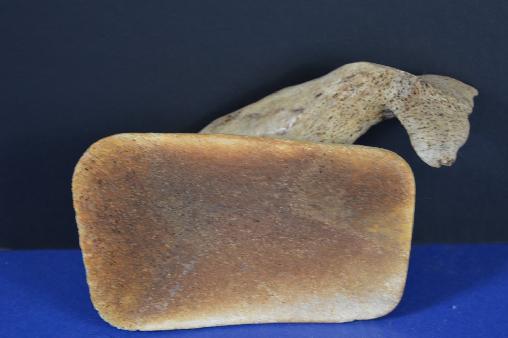 A hand-carved whale figure made from porous whalebone mounted on a metal pin above a rectangular bone plinth base. View XII