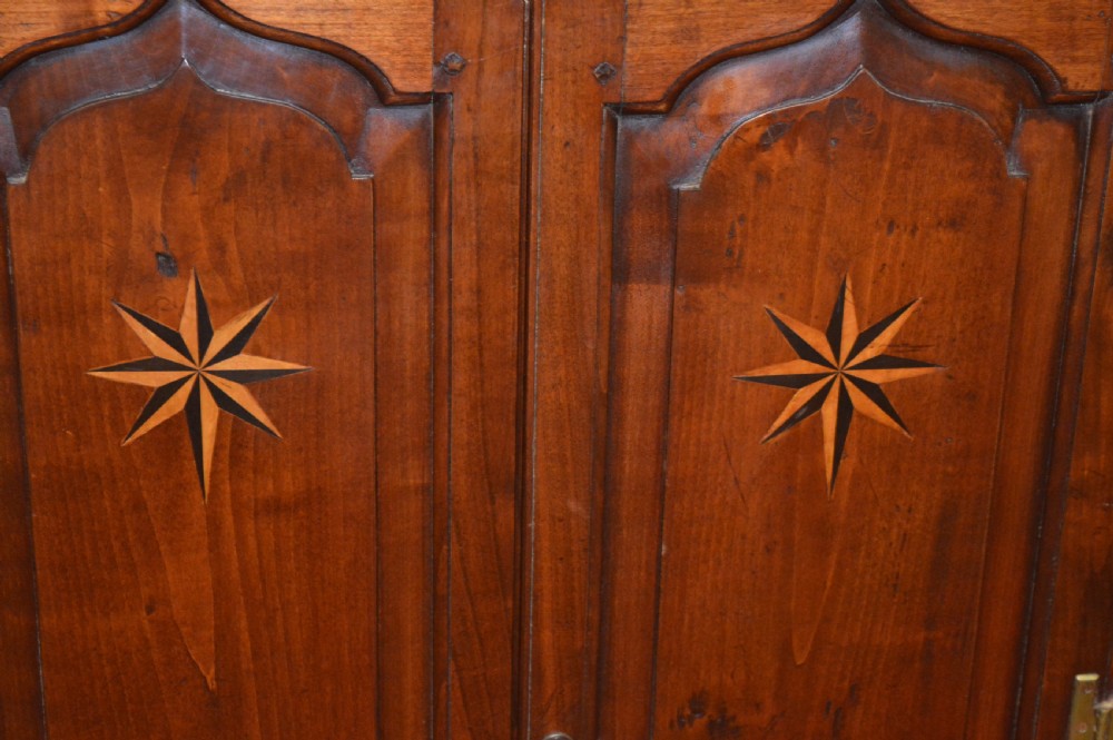 A nineteenth-century mahogany corner hanging cupboard featuring twin panelled doors with inlaid star motifs and brass H-hinges. View III