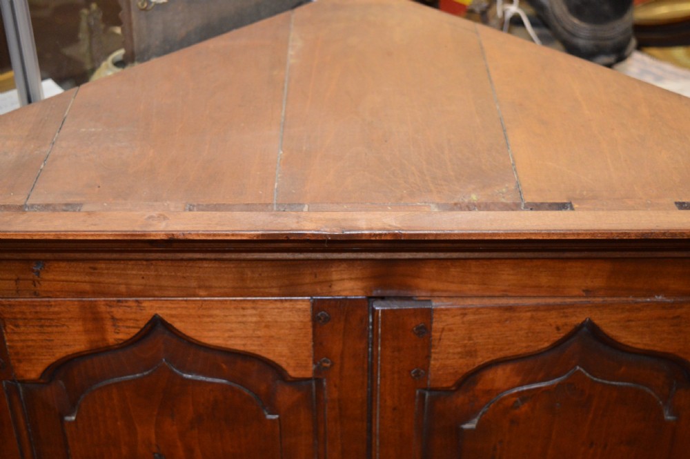 A nineteenth-century mahogany corner hanging cupboard featuring twin panelled doors with inlaid star motifs and brass H-hinges. View V