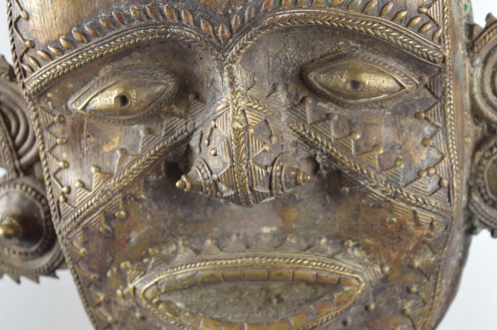 A tall, cast brass African statue featuring a stylized king figure with a spiked crown, elaborate facial details, and a tapered cylindrical base. View XIII