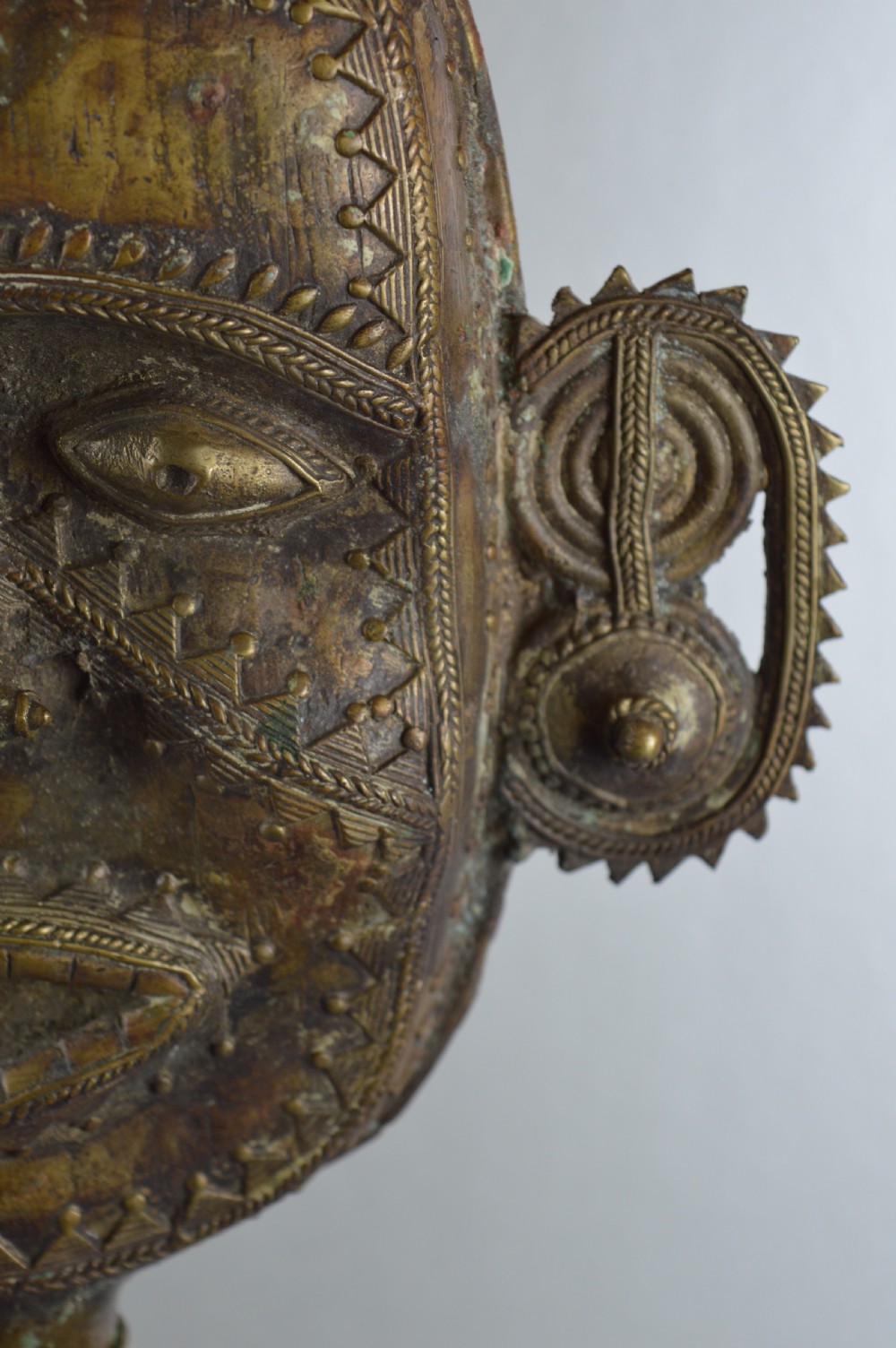 A tall, cast brass African statue featuring a stylized king figure with a spiked crown, elaborate facial details, and a tapered cylindrical base. View XIV