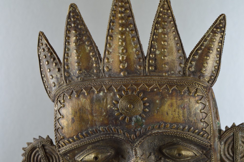 A tall, cast brass African statue featuring a stylized king figure with a spiked crown, elaborate facial details, and a tapered cylindrical base. View XV