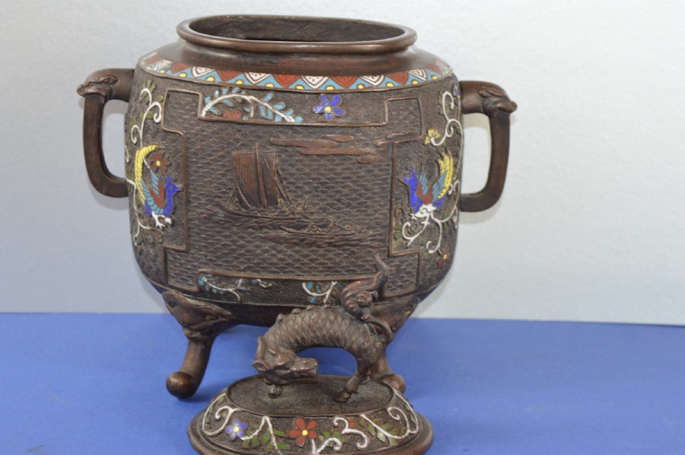 A late nineteenth-century Japanese bronze tripod censer featuring polychrome cloisonne enamel work, relief panels depicting a sailboat, loop handles, and a cover topped with a beast finial. View II