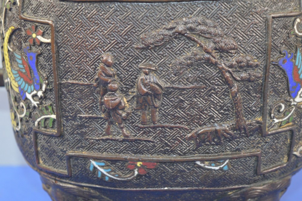 A late nineteenth-century Japanese bronze tripod censer featuring polychrome cloisonne enamel work, relief panels depicting a sailboat, loop handles, and a cover topped with a beast finial. View IX