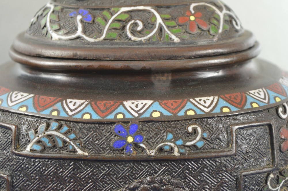 A late nineteenth-century Japanese bronze tripod censer featuring polychrome cloisonne enamel work, relief panels depicting a sailboat, loop handles, and a cover topped with a beast finial. View X