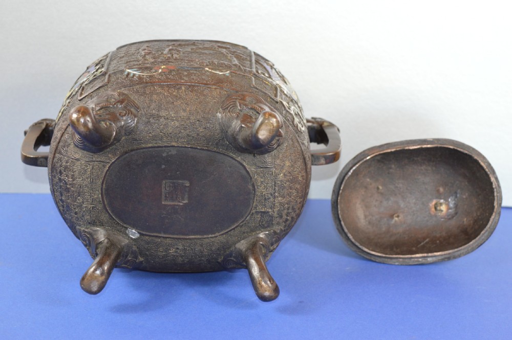 A late nineteenth-century Japanese bronze tripod censer featuring polychrome cloisonne enamel work, relief panels depicting a sailboat, loop handles, and a cover topped with a beast finial. View XI