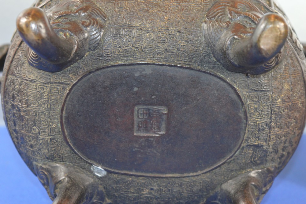 A late nineteenth-century Japanese bronze tripod censer featuring polychrome cloisonne enamel work, relief panels depicting a sailboat, loop handles, and a cover topped with a beast finial. View XII