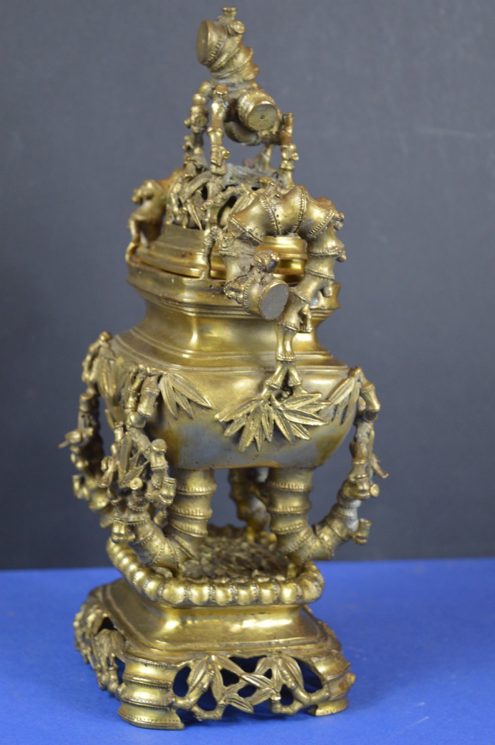 An ornate 19th-century Chinese cast bronze censer featuring bamboo leaf reliefs, sculpted handles, a pierced lid, and an intricate tiered base. View VII