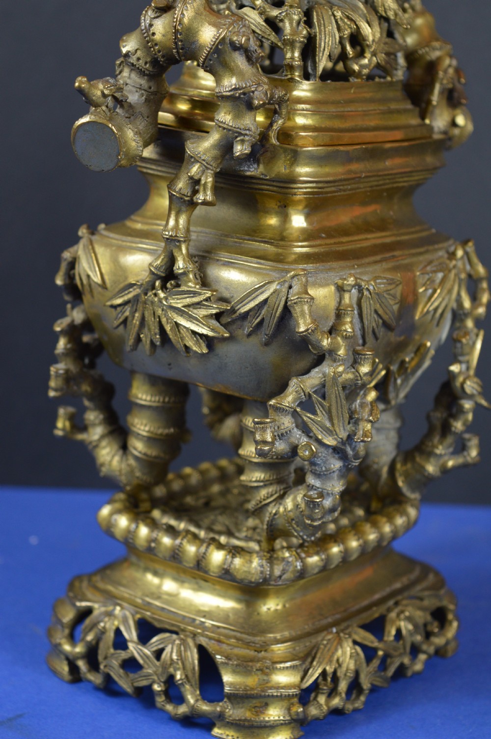 An ornate 19th-century Chinese cast bronze censer featuring bamboo leaf reliefs, sculpted handles, a pierced lid, and an intricate tiered base. View IX