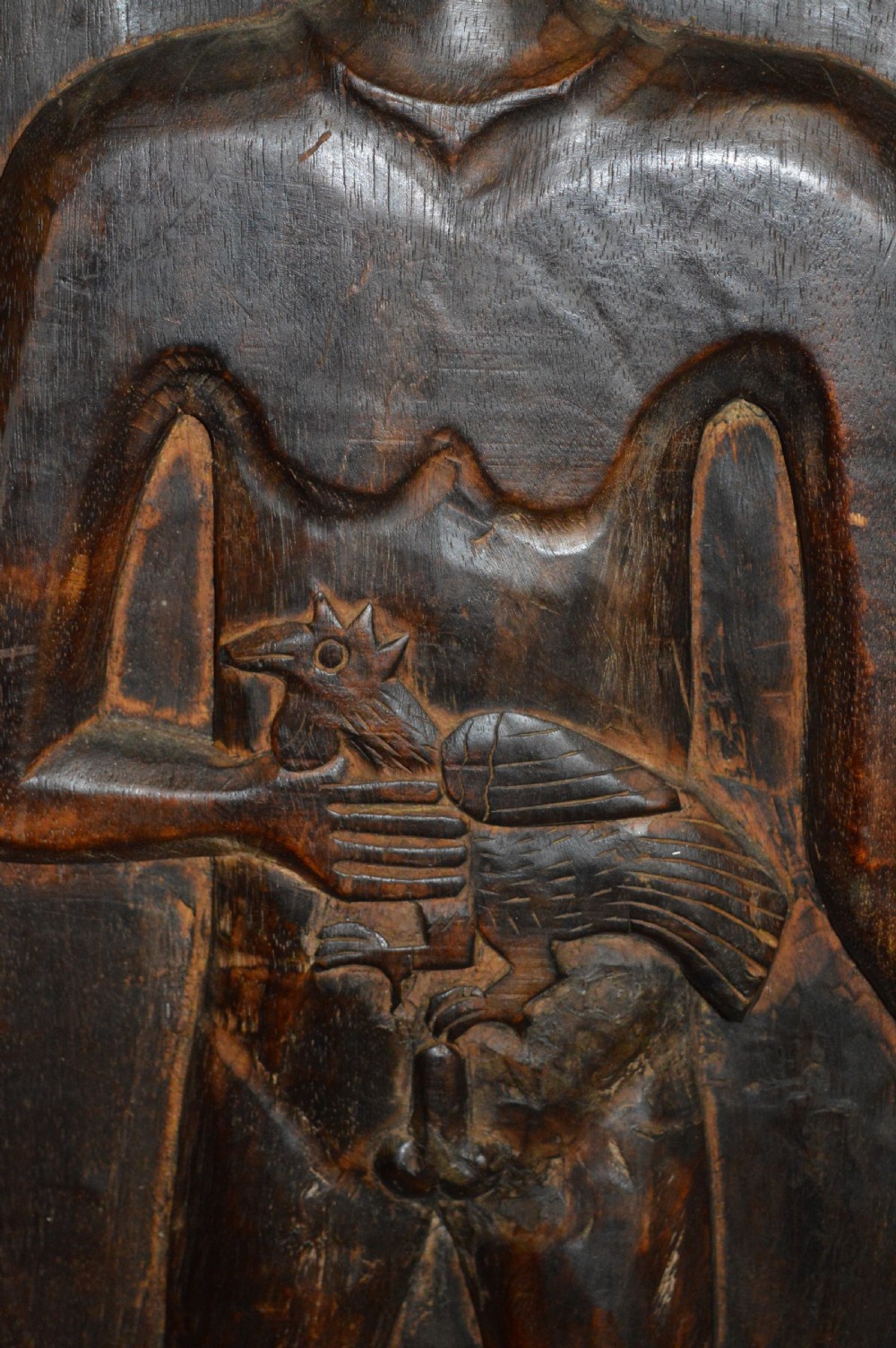 Pair of dark hand-carved wooden doors featuring high-relief human figures holding roosters above water buffalo heads with bone inlaid eyes. View XII