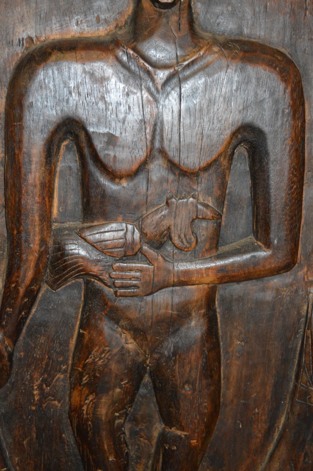 Pair of dark hand-carved wooden doors featuring high-relief human figures holding roosters above water buffalo heads with bone inlaid eyes. View XIX