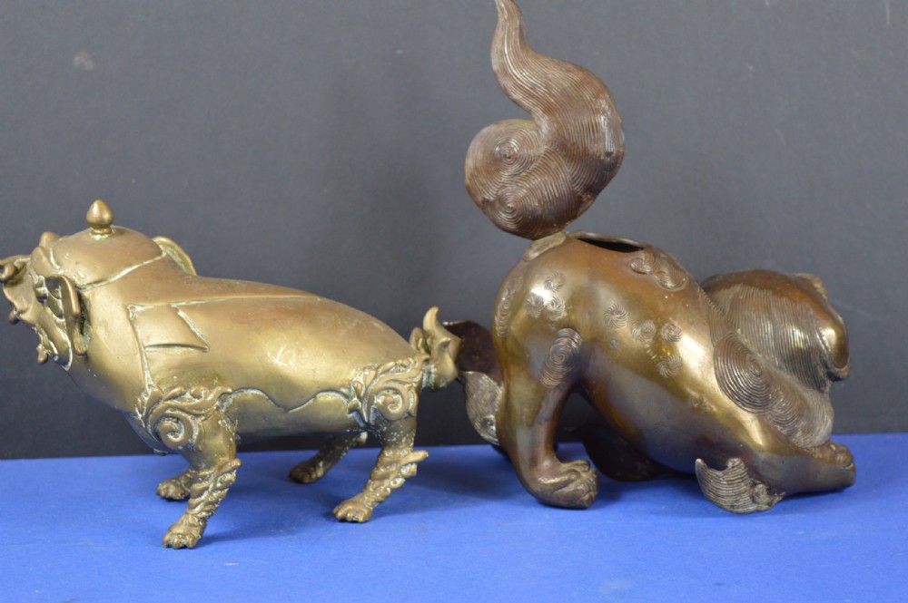 A pair of antique cast bronze Chinese foo dog incense burners with carved scroll details and open mouths. View III
