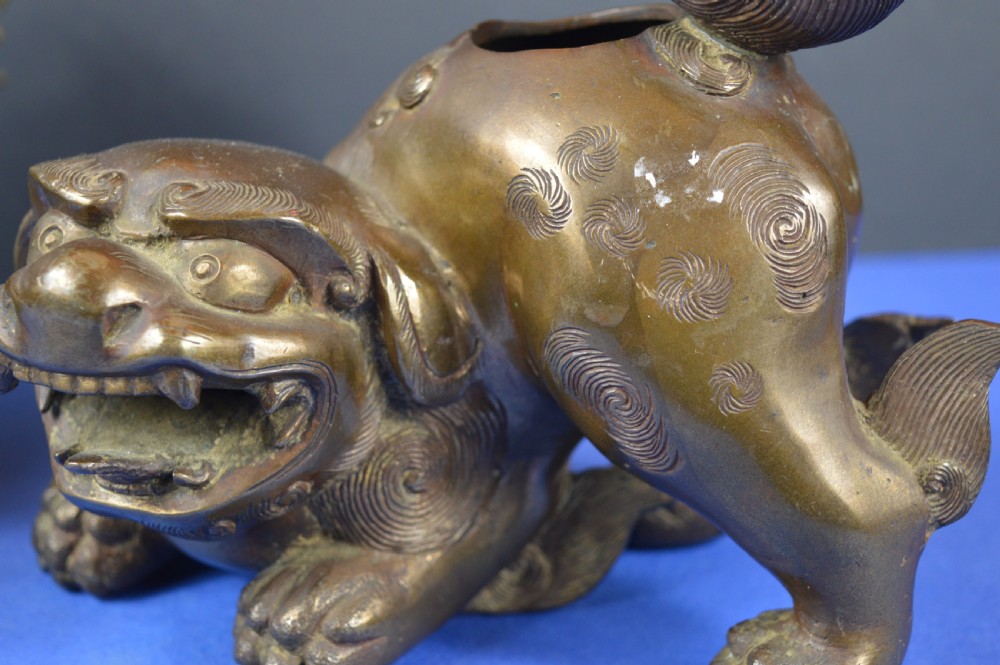 A pair of antique cast bronze Chinese foo dog incense burners with carved scroll details and open mouths. View VI
