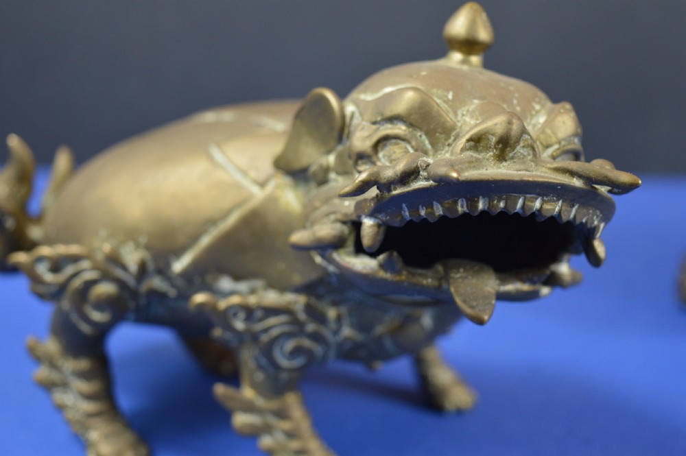 A pair of antique cast bronze Chinese foo dog incense burners with carved scroll details and open mouths. View VII