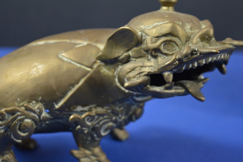 A pair of antique cast bronze Chinese foo dog incense burners with carved scroll details and open mouths. View VIII