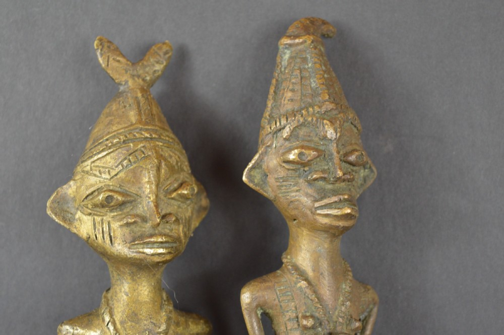 A pair of cast bronze Yoruba ceremonial staffs featuring sculpted human figures as finials above flat, patterned brass blades. View IV
