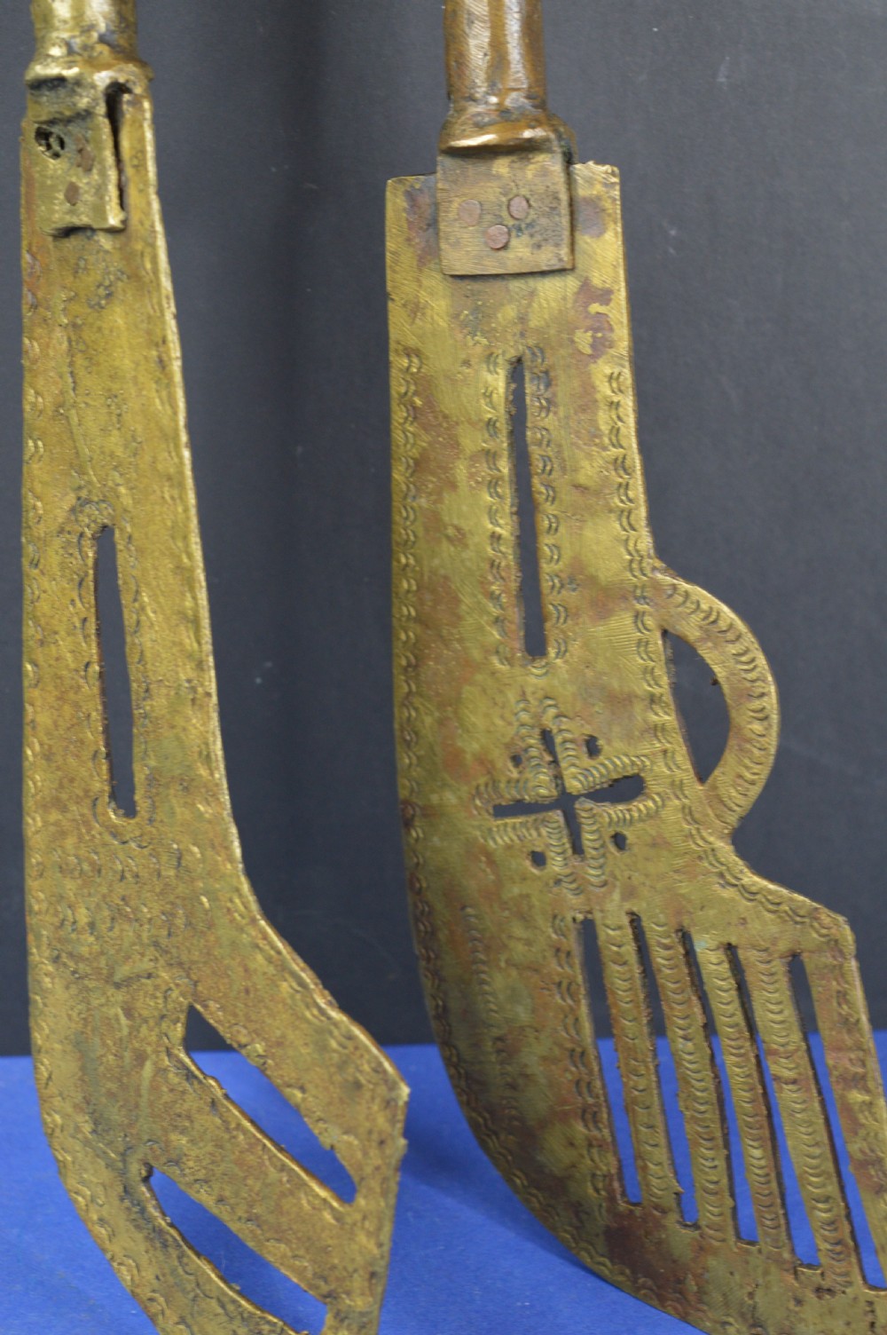 A pair of cast bronze Yoruba ceremonial staffs featuring sculpted human figures as finials above flat, patterned brass blades. View XI