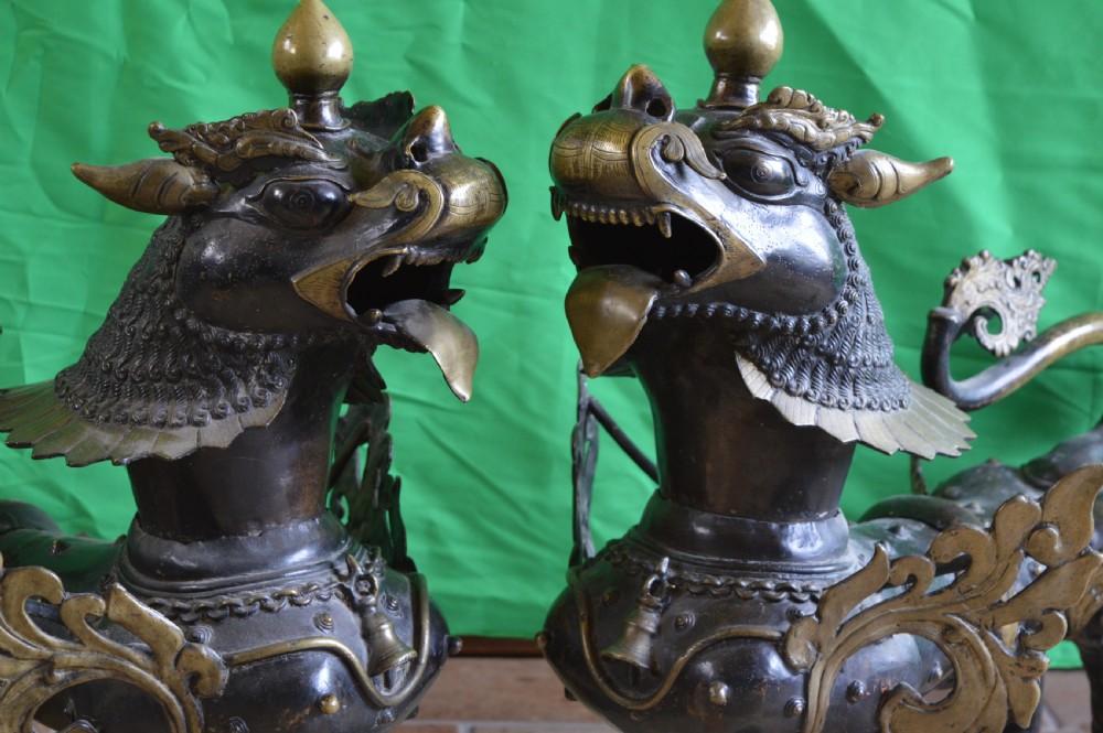 A pair of substantial dark bronze Tibetan temple lions featuring raised tails, stylised scale details, and brass accents. View III