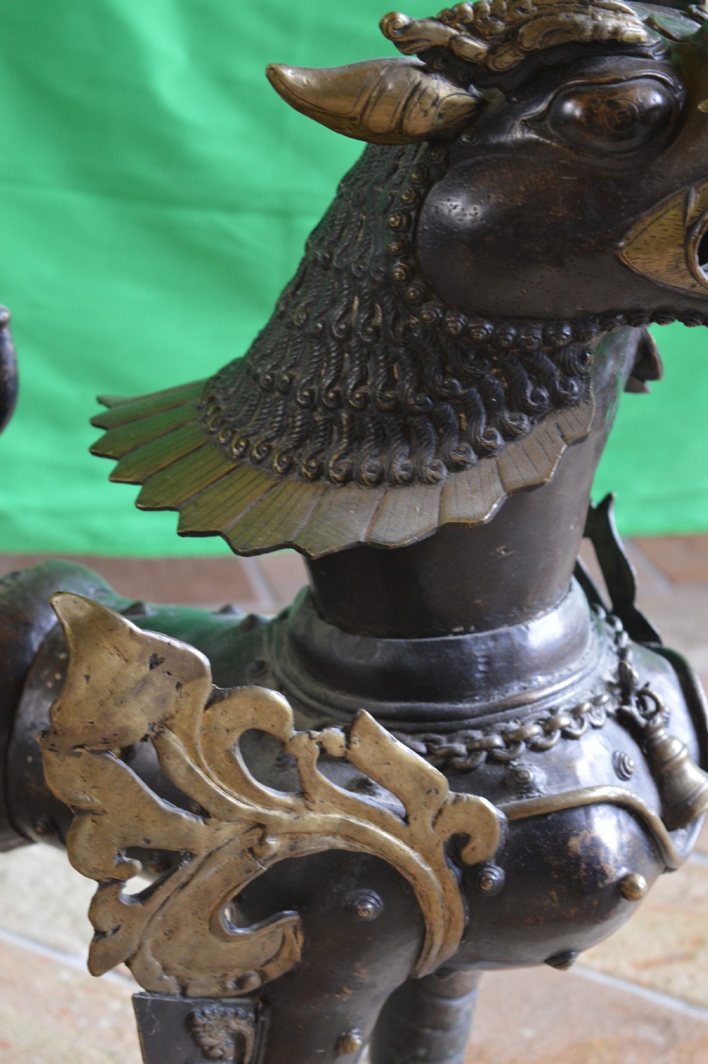 A pair of substantial dark bronze Tibetan temple lions featuring raised tails, stylised scale details, and brass accents. View IX
