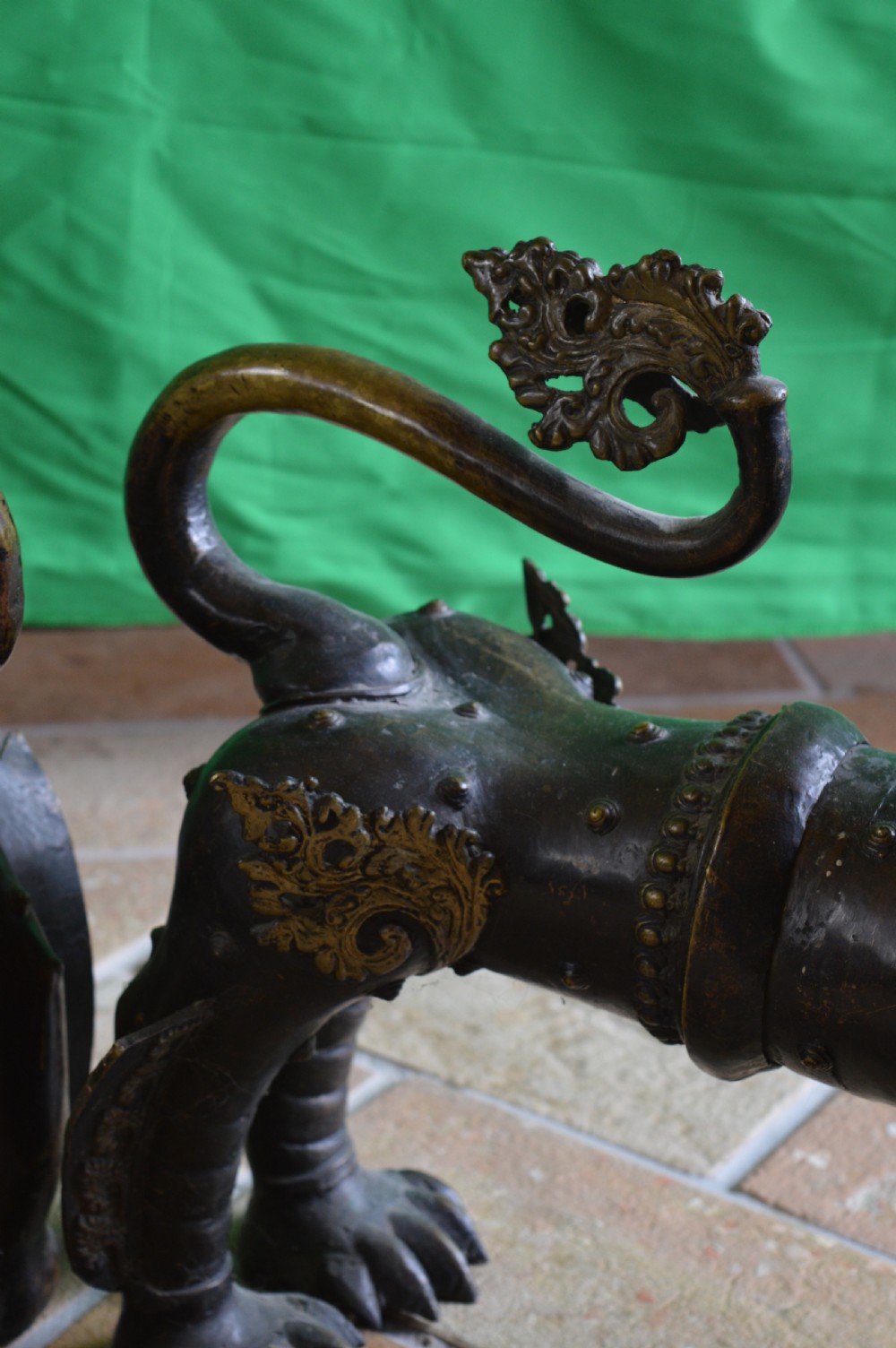 A pair of substantial dark bronze Tibetan temple lions featuring raised tails, stylised scale details, and brass accents. View X
