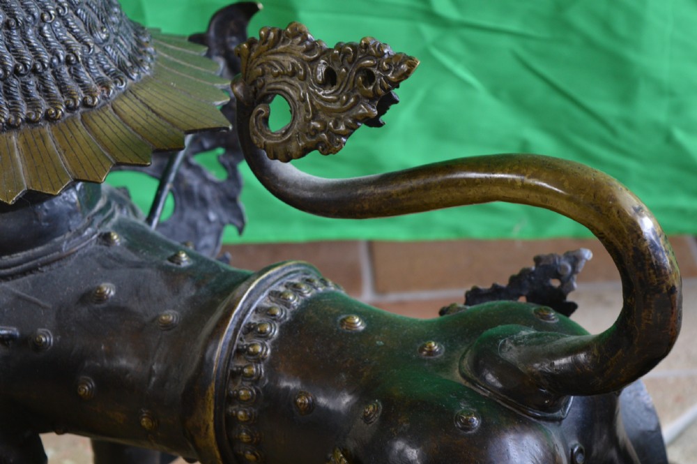 A pair of substantial dark bronze Tibetan temple lions featuring raised tails, stylised scale details, and brass accents. View XIII
