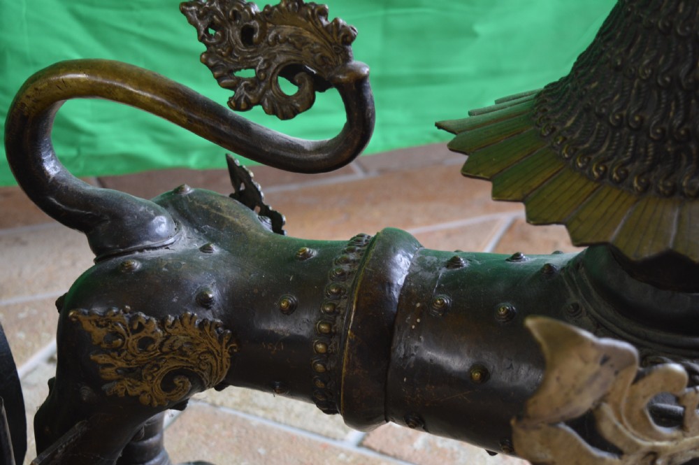 A pair of substantial dark bronze Tibetan temple lions featuring raised tails, stylised scale details, and brass accents. View XIV