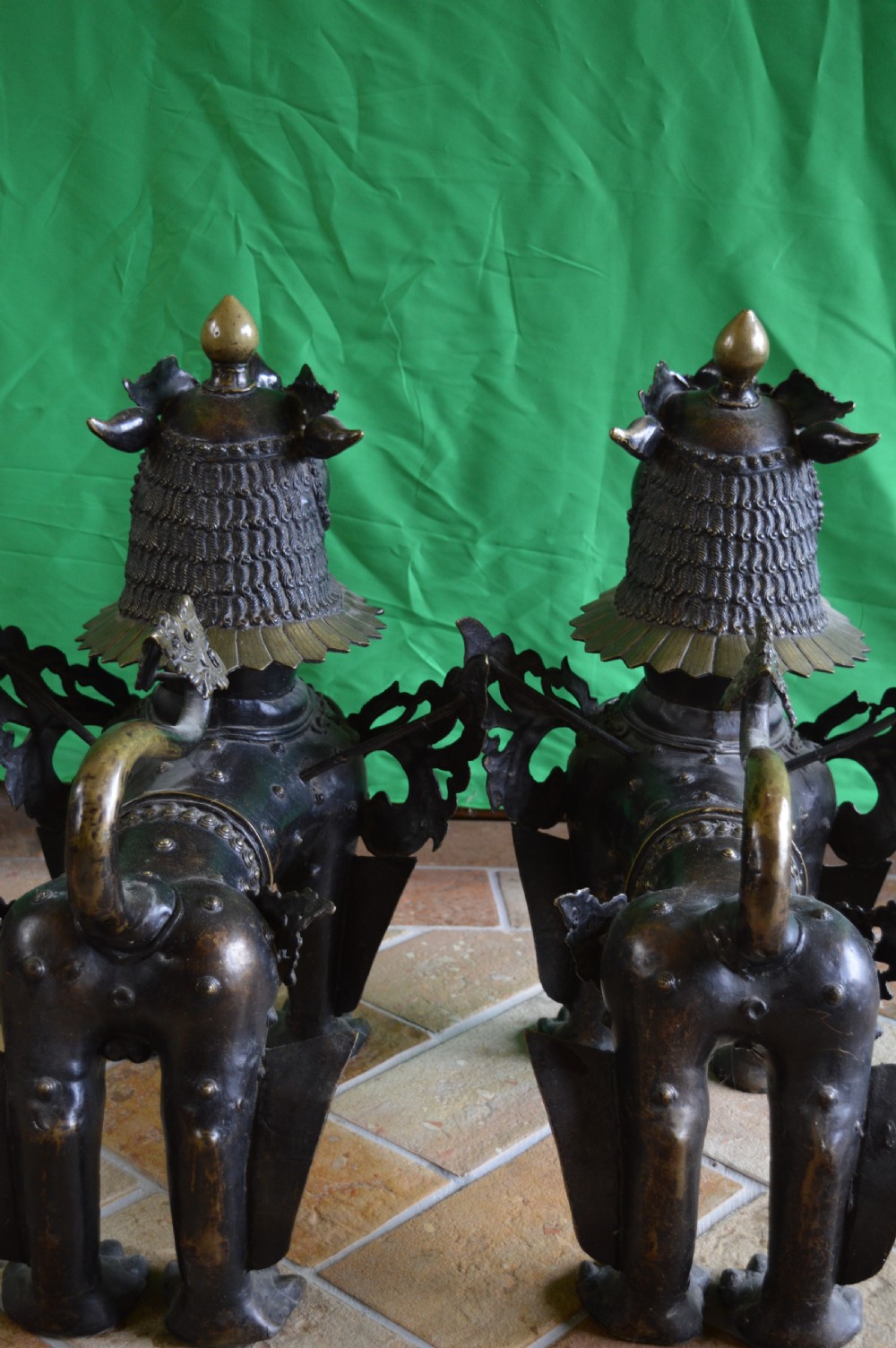 A pair of substantial dark bronze Tibetan temple lions featuring raised tails, stylised scale details, and brass accents. View XV