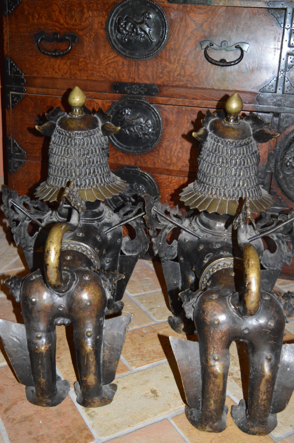 A pair of substantial dark bronze Tibetan temple lions featuring raised tails, stylised scale details, and brass accents. View XXII