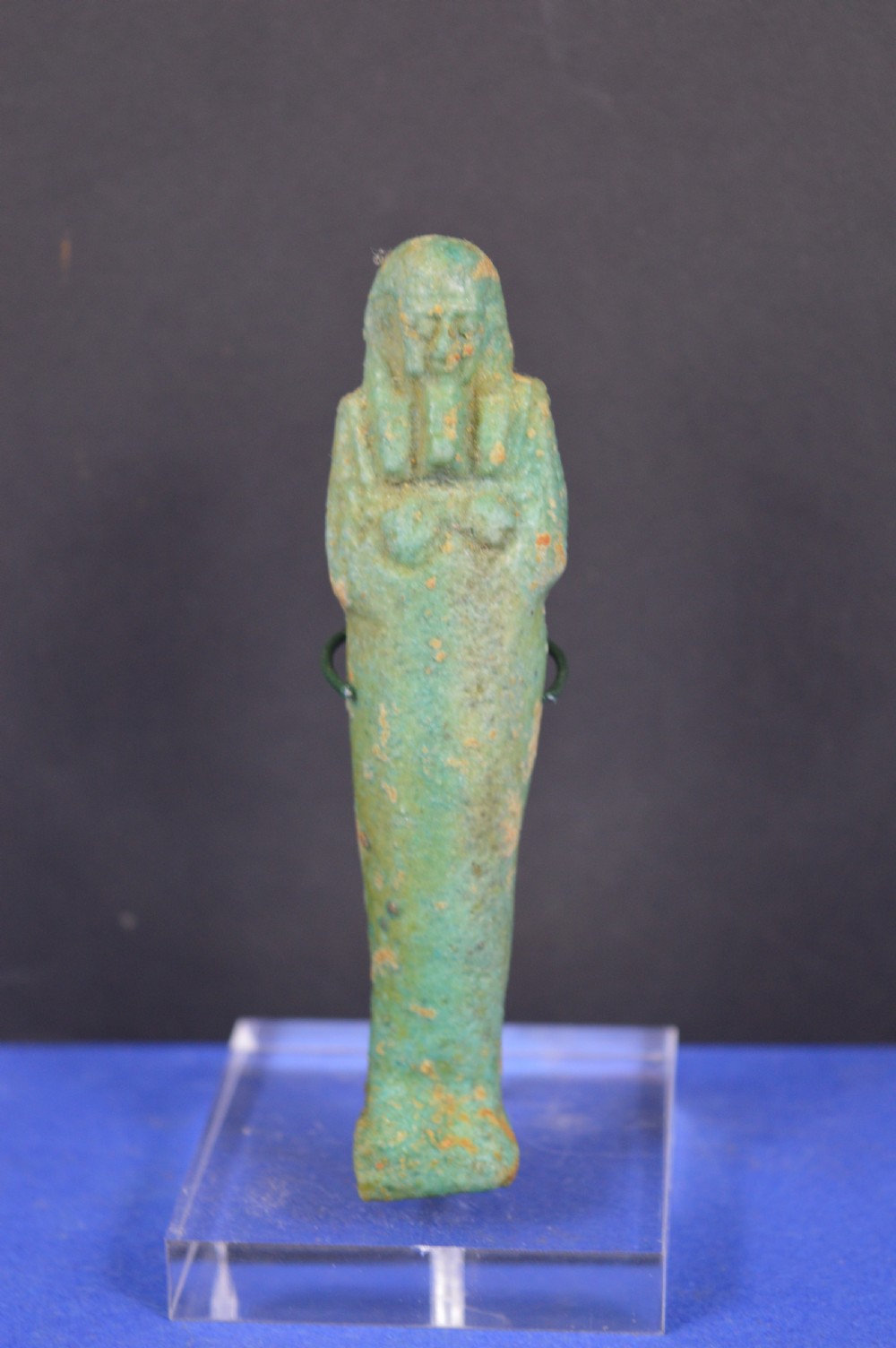 A small ancient Egyptian mummiform shabti statuette crafted from light turquoise green glazed faience.