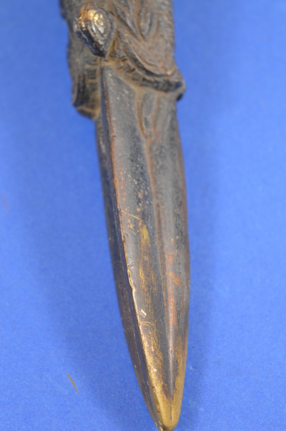 A 19th-century Tibetan bronze phurba featuring a wrathful deity head pommel, central vajra handles, and a three-sided blade extending from a makara mouth. View VIII