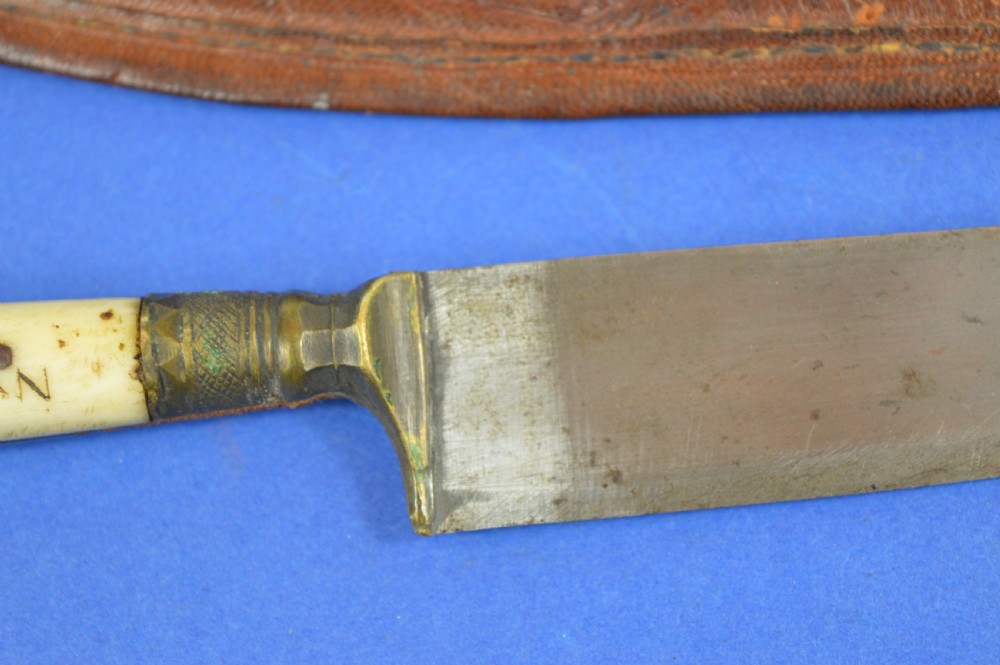 A nineteenth-century Anglo-Afghan war knife featuring a steel blade, a bone handle carved with the word KANDAHAR, and a stamped brown leather sheath. View IX