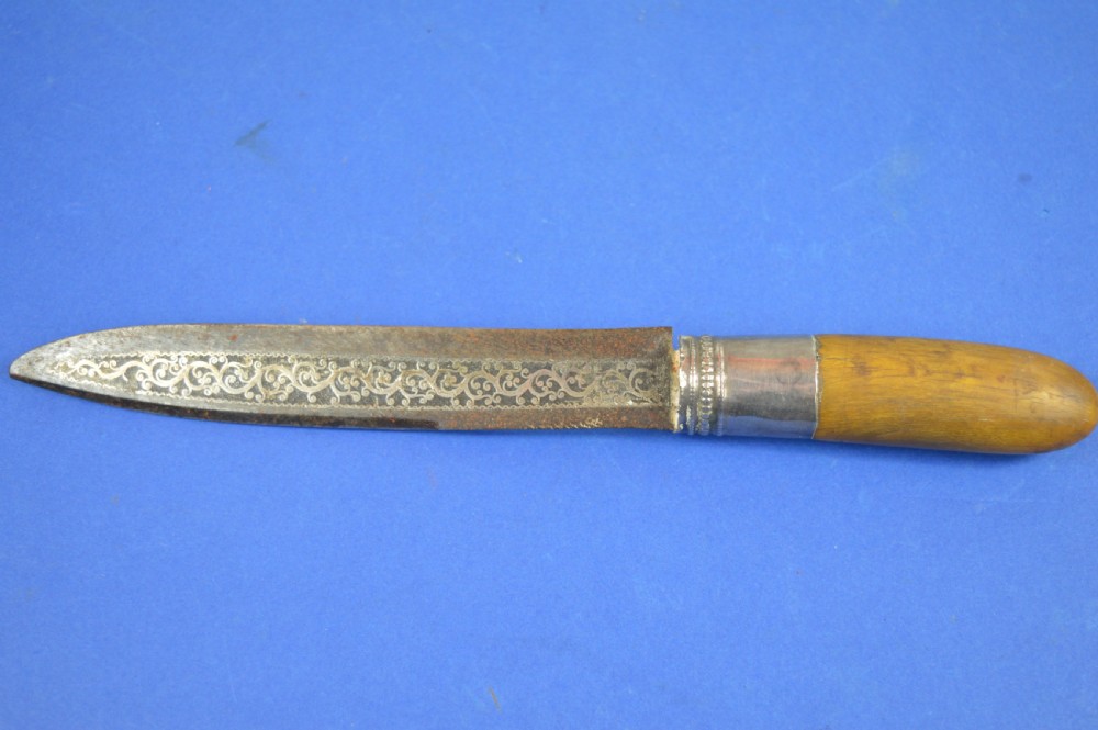 A 19th-century ceremonial knife with a steel blade featuring silver scrollwork inlay, a silver metal collar, and a smooth horn handle.