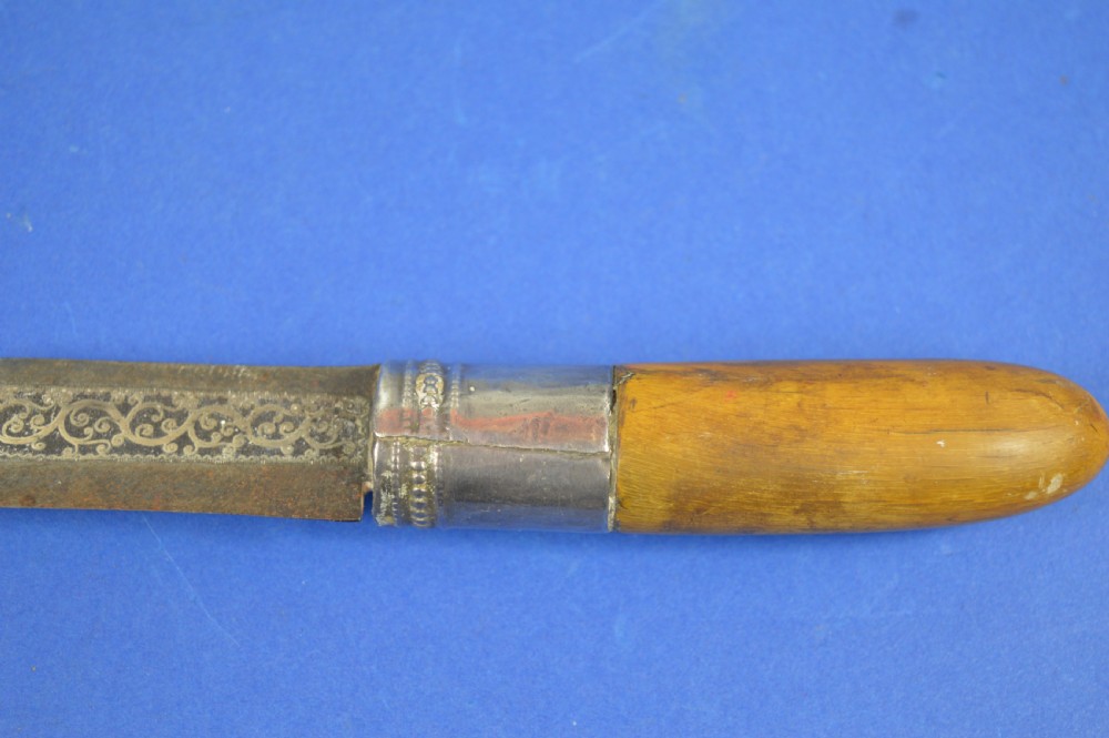 A 19th-century ceremonial knife with a steel blade featuring silver scrollwork inlay, a silver metal collar, and a smooth horn handle. View II
