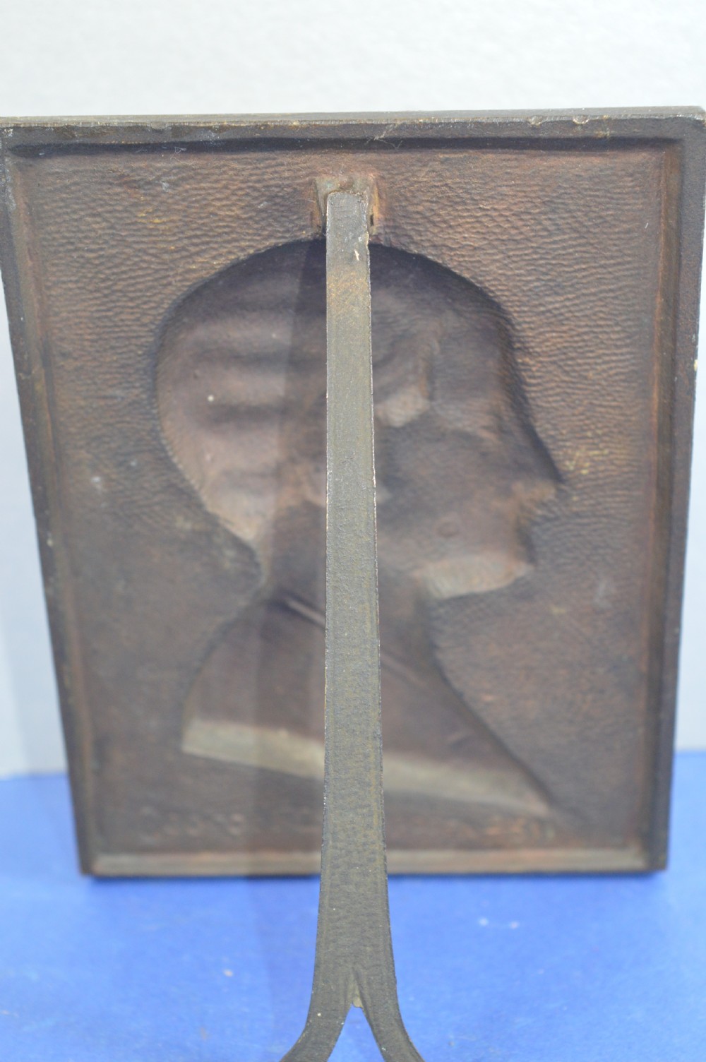 An Art Deco dark brown bronze relief plaque featuring a side profile portrait of Queen Astrid against a textured background with inscribed lettering. View VII